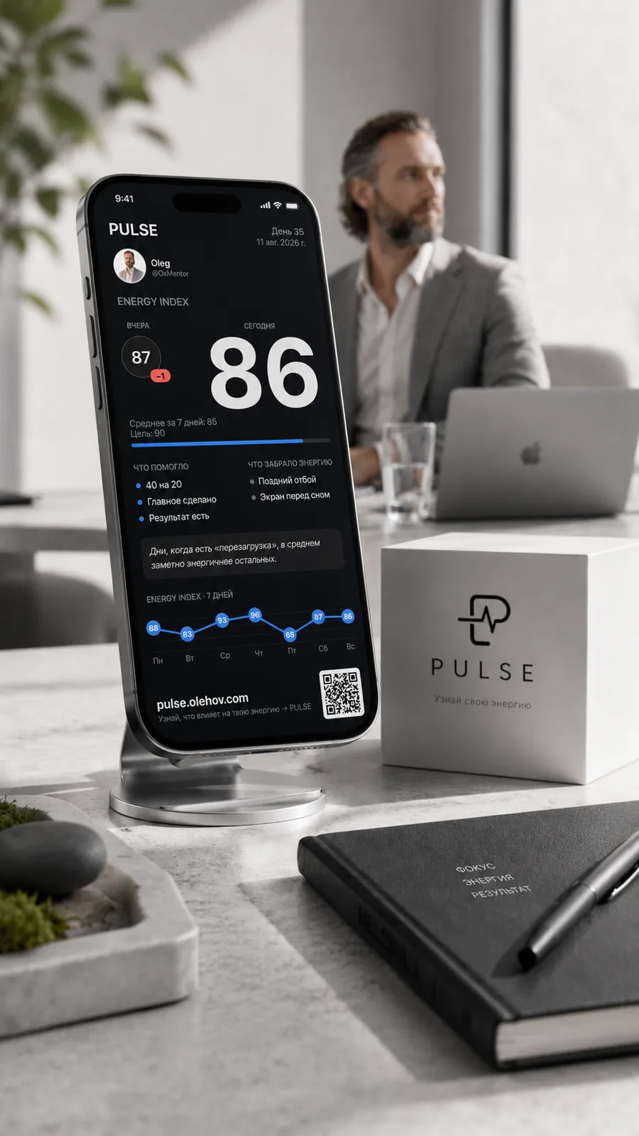 PULSE на iPhone на подставке: экран Energy Index 86, вчера 87, график за неделю, рядом брендированная упаковка PULSE